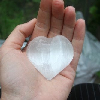 Seleniet hart van 7cm breed in een hand