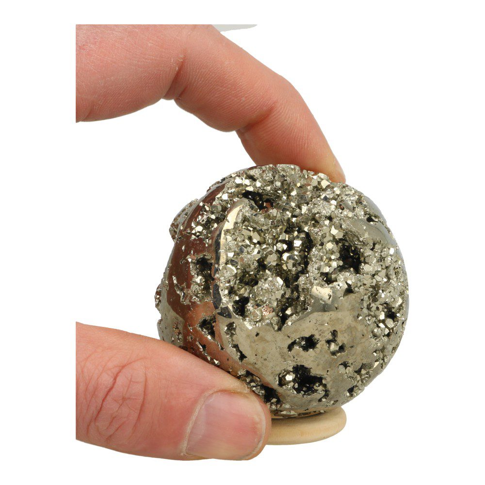Overzichtsfoto in hand van Leuke pyriet bol vol met holtes en kristallen met een diameter van 59mm op houten ring