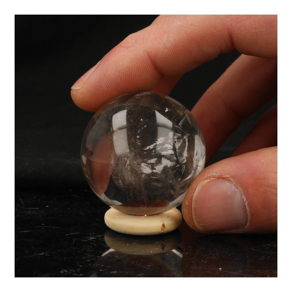 A-kwaliteit heldere bergkristal bol met diameter van 4cm op houten ring, in hand