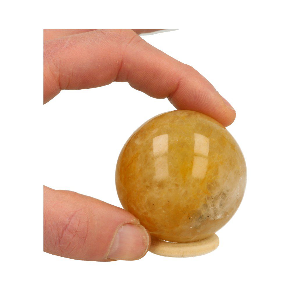 Overzicht in hand van Fijn formaatje golden healer bol met diameter van 55mm op houten ring