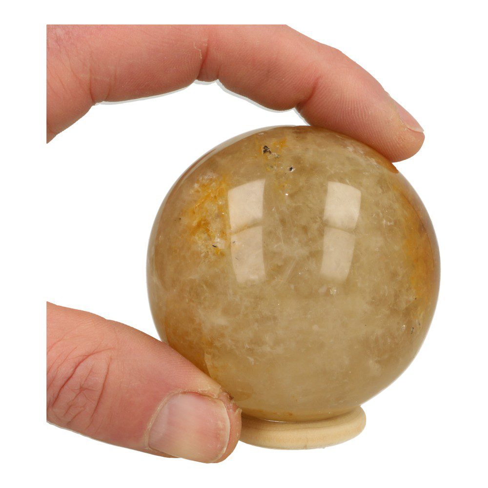 Overzicht in hand van mooie lichtgele golden healer bol met diameter van 66mm en houten ring