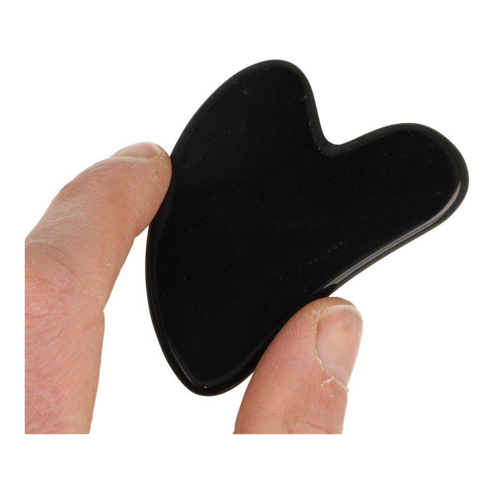 Zwarte obsidiaan Gua Sha of gezichtschraper in de hand