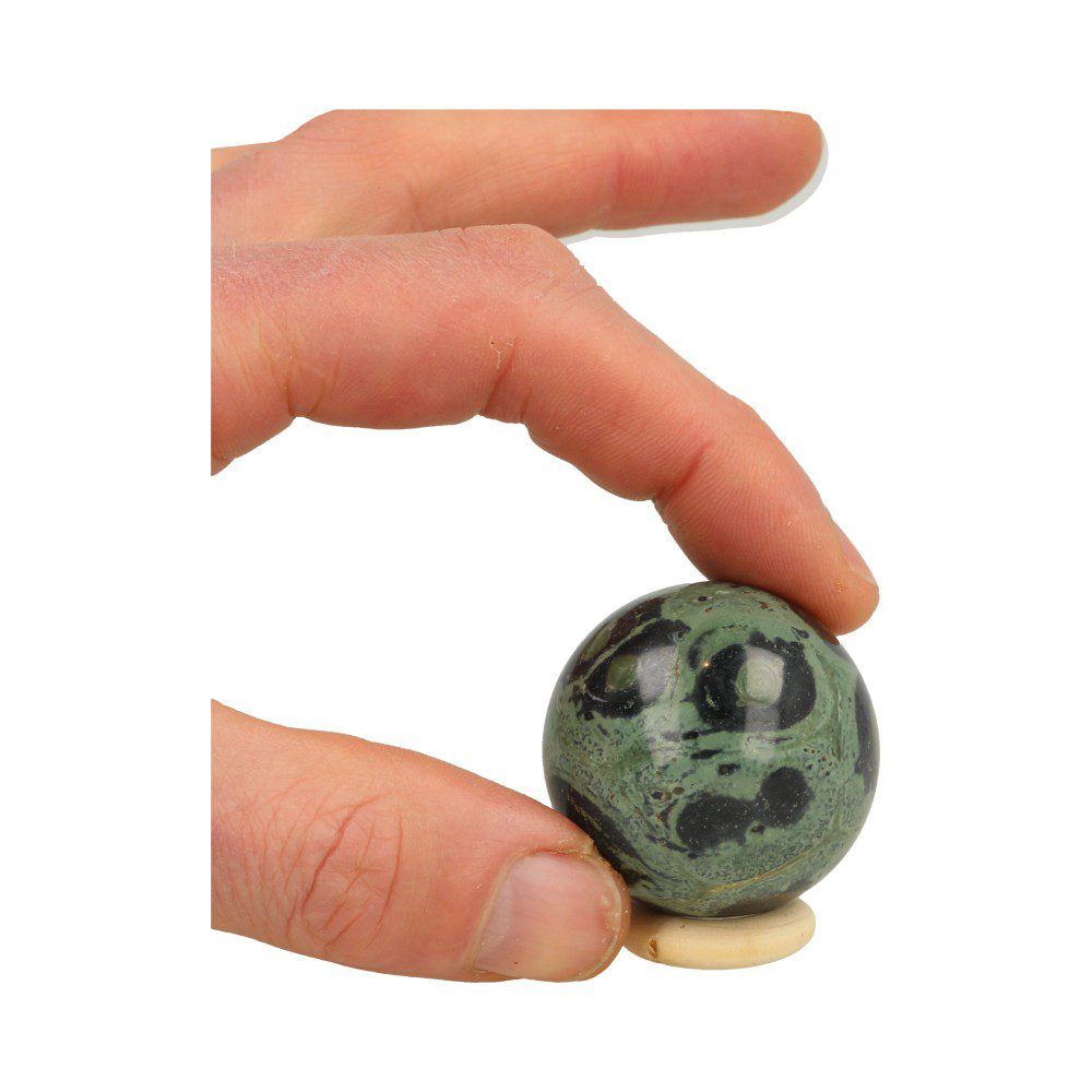 Fraaie Kabamba jaspis bol met diameter tussen 4-5cm op houten ring, voorbeeld 3 in hand