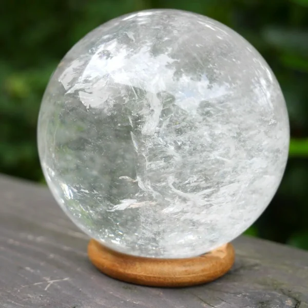 Fraaie heldere bergkristal bol met een diameter van 8cm op houten ring