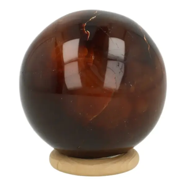 Mooie donkere carneool bol met diameter van 55mm op houten ring