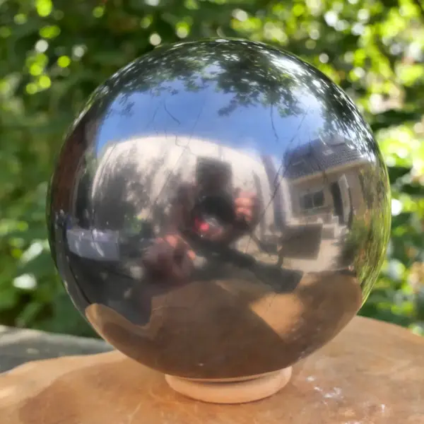 Fraaie glanzend zwarte shungiet bol met diameter van circa 12,5cm op houten ring