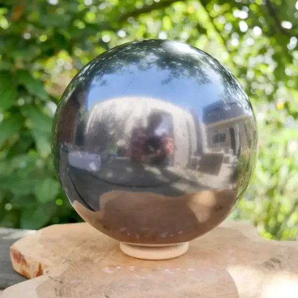 Fraaie glanzend grijze shungiet bol met diameter van 14cm op houten ring